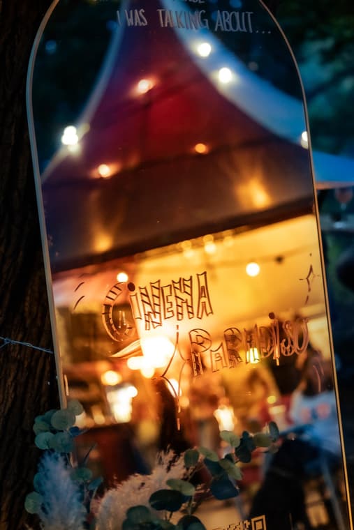 Gravierter Spiegel mit dem Schriftzug Cinema Paradiso, Lichterketten spiegeln sich