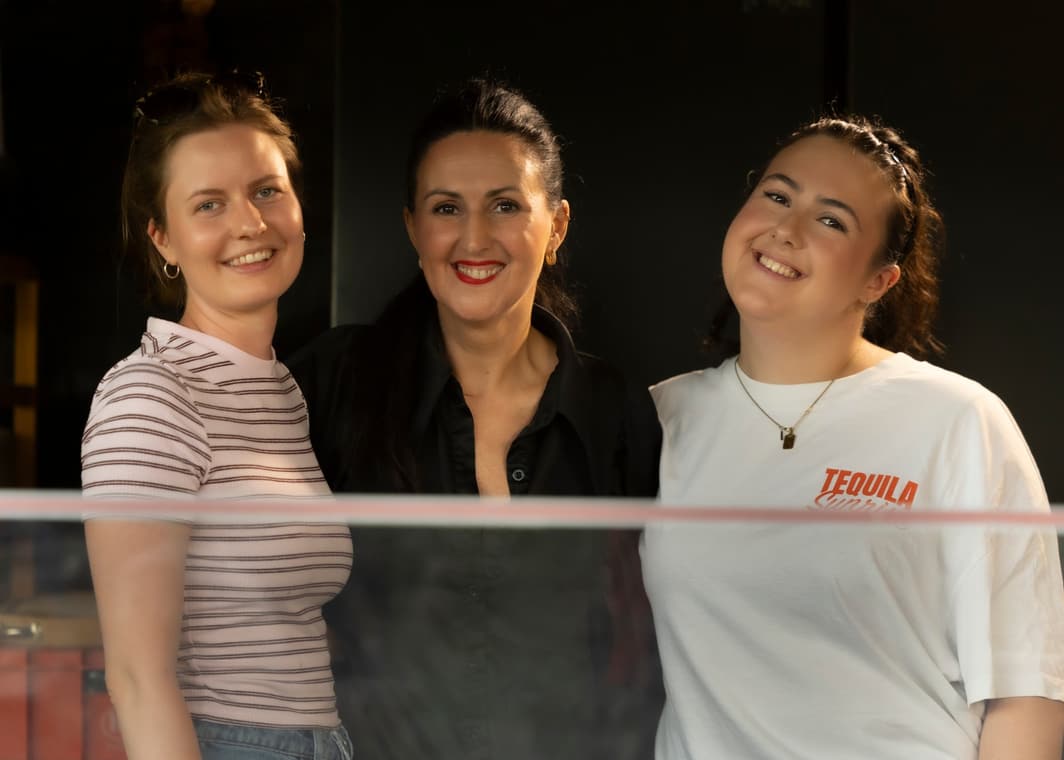 Drei Frauen aus dem Team lächeln in die Kamera