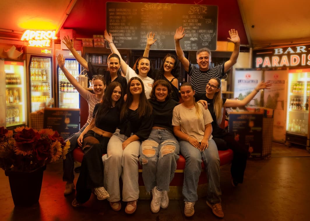 Das ganze Team hinter der Bar Paradiso winkt in die Kamera