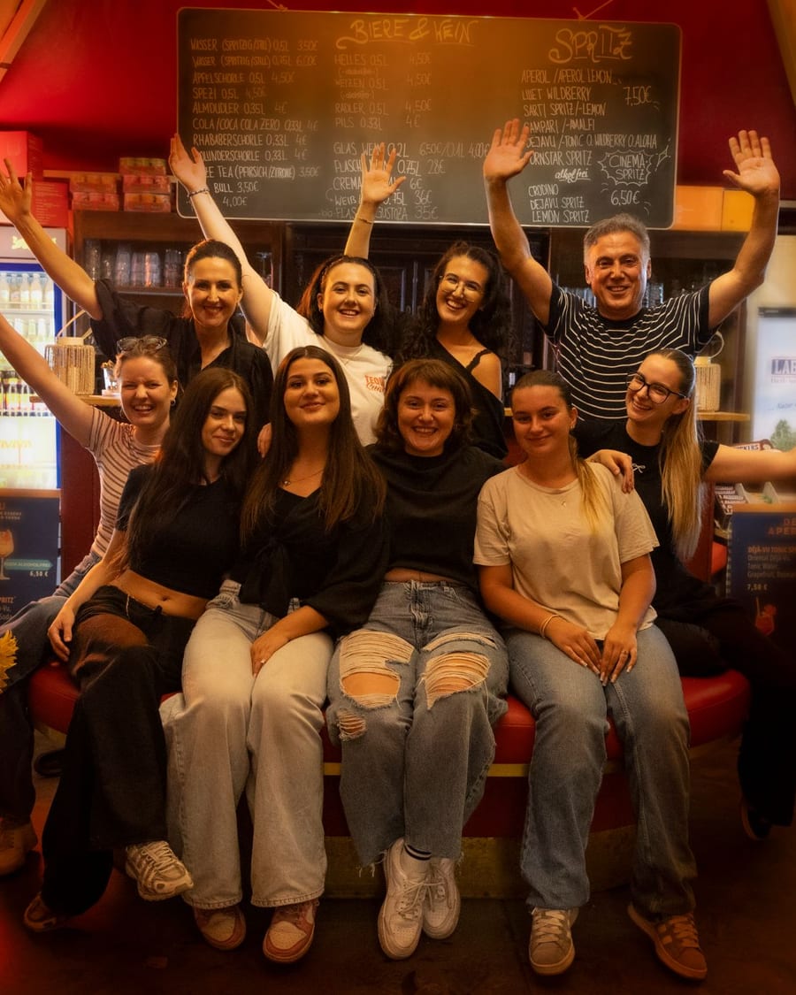 Das Team von Cinema Paradiso vor der Bar Paradiso, alle winken in die Kamera